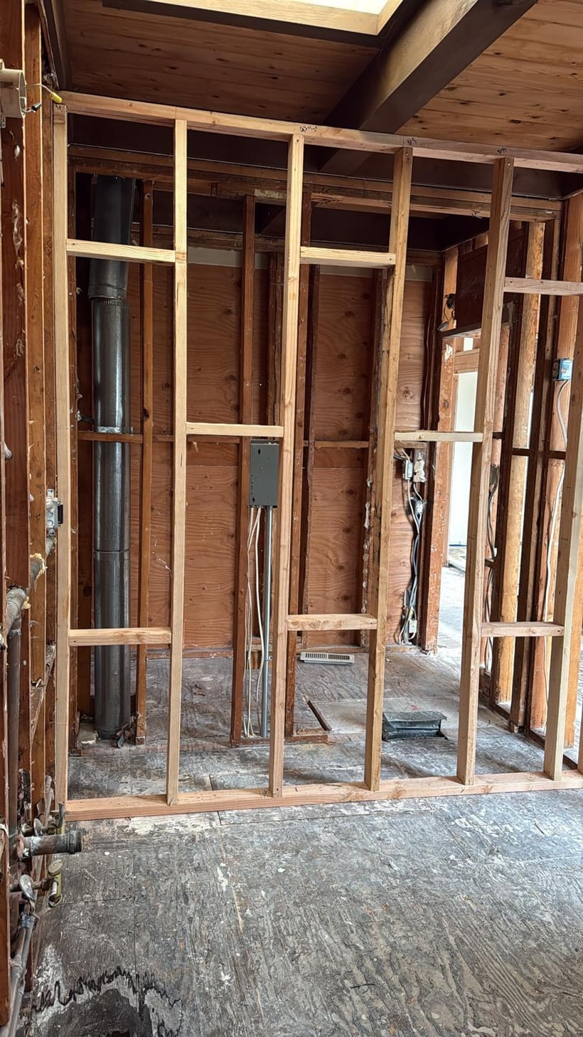 Interior framing repair with exposed wall framing and structural opening work